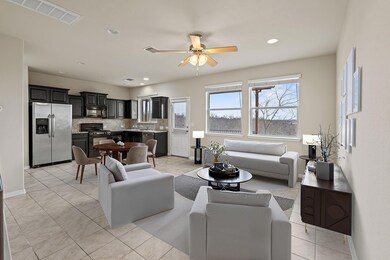 Living room featuring ceiling fan, light tile pat