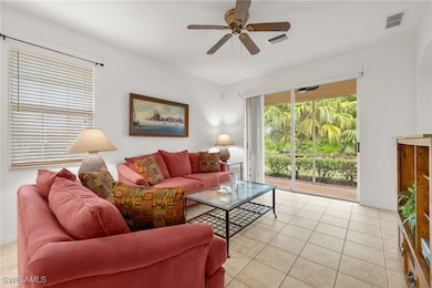 Living room with ceiling fan and light tile patter
