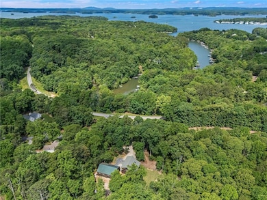 Aerial view of property's location with a forest and a large body of water