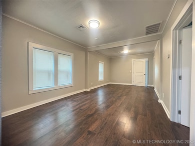 Unfurnished room with crown molding, dark wood-typ