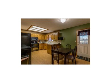 Hardwoods grace the eat-in kitchen with door to sp