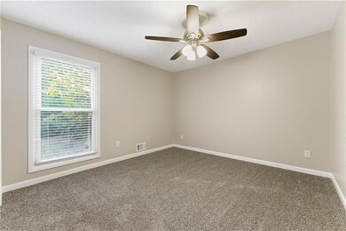 Carpeted spare room with baseboards and a ceiling fan