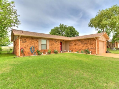 Ranch-style home with brick siding, an attached ga