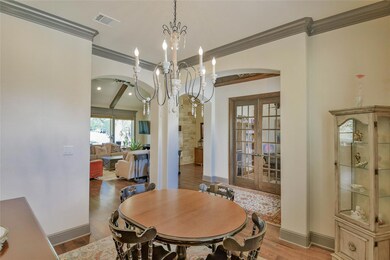 Dining room featuring french doors, an inviting chandelier, light hardwood / wood-style flooring, and ornamental molding