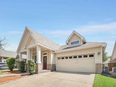 View of front of home with brick siding, covered porch, driveway, and a shingled roof