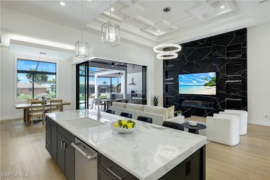 Kitchen with dark cabinetry, open floor plan, stai