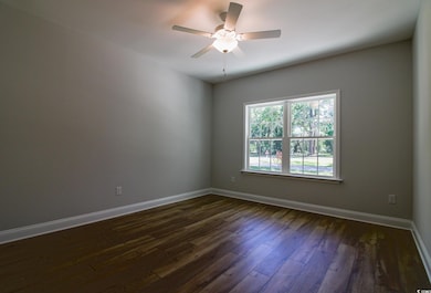 Spare room with baseboards, ceiling fan, and dark 