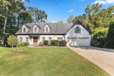 Cape cod-style house with concrete driveway, a front yard, brick siding, and a garage