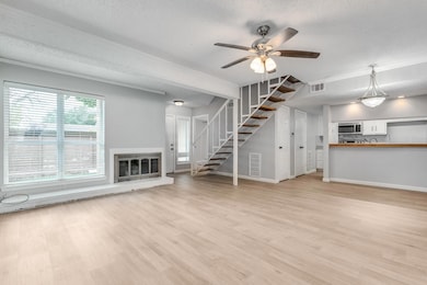 Unfurnished living room featuring ceiling fan, lig