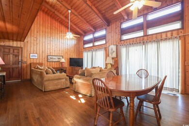 Dining space featuring beamed ceiling, wood finished floors, wood ceiling, and a ceiling fan