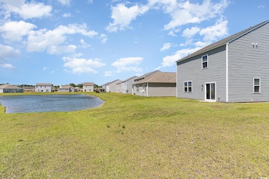 View of green lawn featuring a residential view and a water view