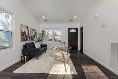 Living room with lofted ceiling and dark hardwood