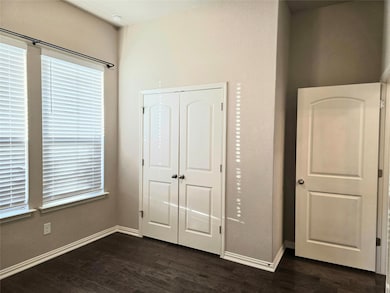 Unfurnished bedroom with dark wood-type flooring and a closet