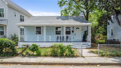 View of front of house featuring fence and a porch