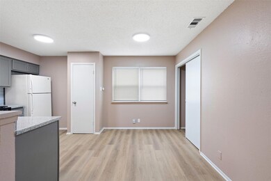 Kitchen with baseboards, visible vents, light woo