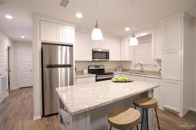 Kitchen featuring stainless steel appliances, a sink, dark wood-style flooring, a center island, and recessed lighting