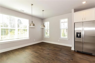 Kitchen featuring visible vents, baseboards, stain