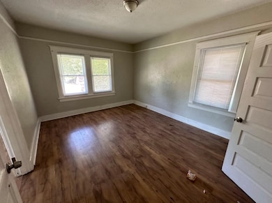 Spare room with dark hardwood / wood-style floors and a textured ceiling