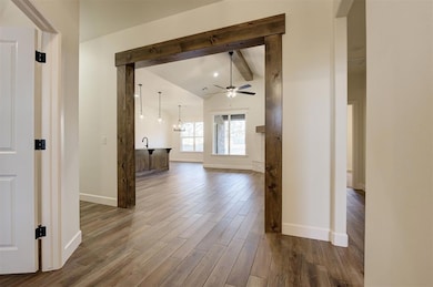 Hall featuring vaulted ceiling with beams, sink, a