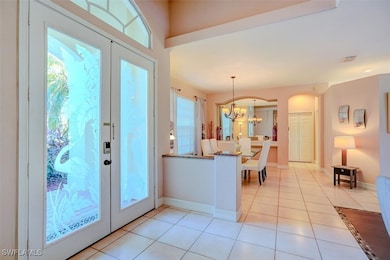 Foyer entrance with a chandelier, light tile patte