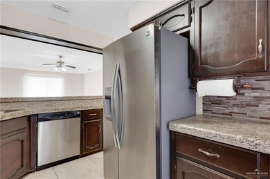 Kitchen with stainless steel appliances, backsplash, dark brown cabinets, and ceiling fan