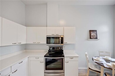 Kitchen featuring light wood-type flooring, stainless steel appliances, and white cabinetry