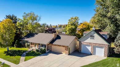 View of front of home featuring a chimney, a porch, concrete driveway, a garage, and a shingled roof