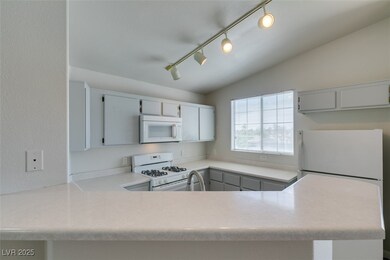 Kitchen with light countertops, lofted ceiling, a
