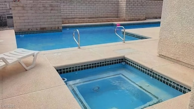 View of swimming pool featuring an in-ground hot t