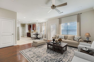 Living area with recessed lighting, a ceiling fan, light wood-type flooring, and crown molding
