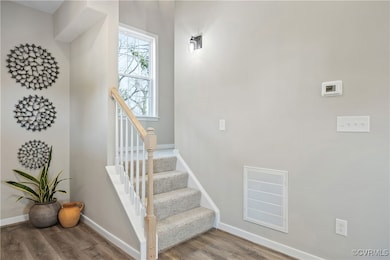 Stairs featuring visible vents, baseboards, and wo