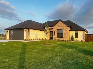 View of front of property with concrete driveway, fence, a shingled roof, and a front yard