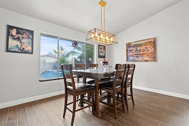 Dining area with wood finished floors and vaulted ceiling