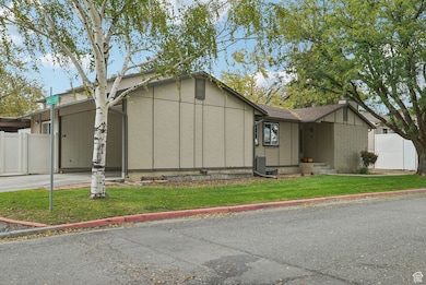 View of front of property featuring brick siding, an attached carport, and a chimney