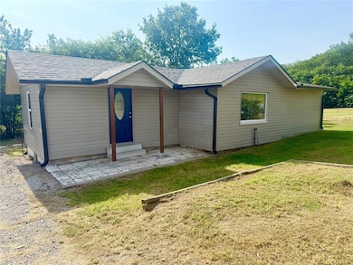 Ranch-style home featuring roof with shingles, a front lawn, a patio area, and entry steps