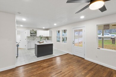 Kitchen featuring ceiling fan, white cabinetry, ba
