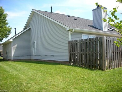 Right rear view of home shows some of the fenced in patio area.