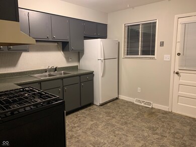 Kitchen with gas stove and refrigerator.