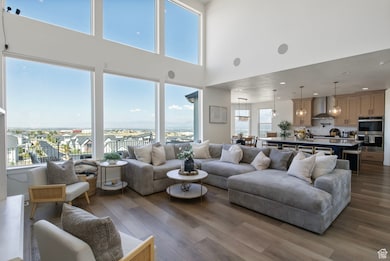 Living room featuring dark wood-style floors, a towering ceiling, and recessed lighting
