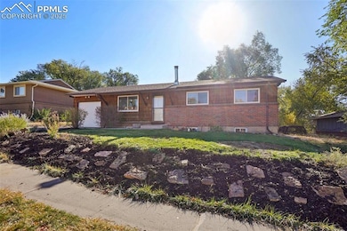 Ranch-style home featuring brick siding, a front yard, and a garage