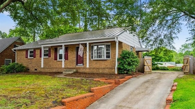 Large front yard with paved driveway access to fully fenced backyard.