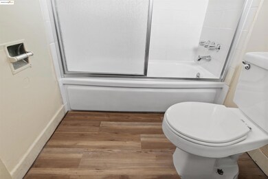 Bathroom featuring wood finished floors and bathing tub / shower combination