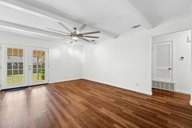 Empty room featuring beamed ceiling, hardwood / w