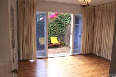 Sunny front bedroom with doors to side patio area.