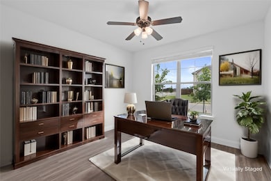 Office area with light wood-style flooring and a ceiling fan