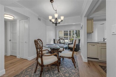 Dining area featuring a chandelier, sink, ornamental molding, and light wood-type flooring