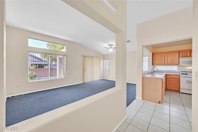 Kitchen with light countertops, plenty of natural light, white appliances, open floor plan, and lofted ceiling