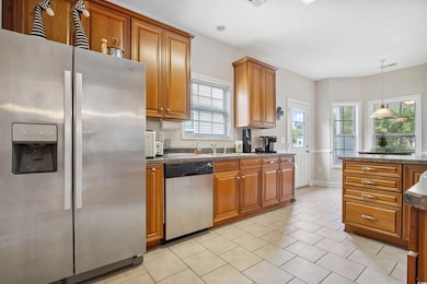 Kitchen featuring appliances with stainless steel finishes, brown cabinets, and plenty of natural light