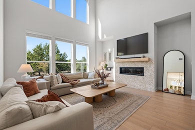 Vaulted ceilings and soaring windows flood the room with sunlight, creating a sense of openness that feels both luxurious and livable.