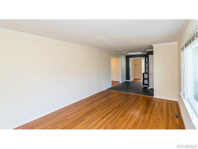 The large living room features gorgeous hardwood f